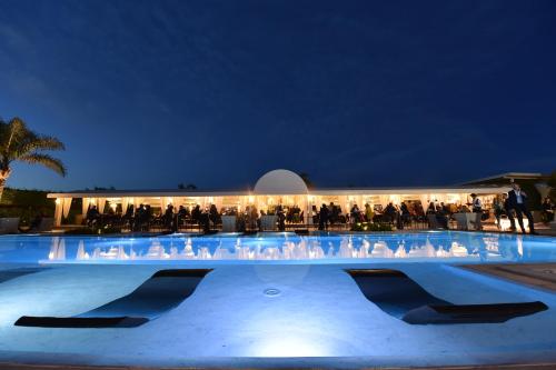 a group of people standing in front of a building at night at Hotel Royal Paestum in Paestum