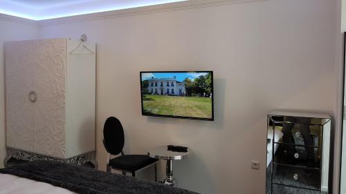 a bedroom with a tv hanging on the wall at Pension Gockels-Auszeit in Bad Wildungen