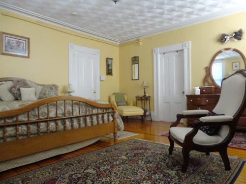 a living room with a bed and a chair at Historic Hill Inn in Newport