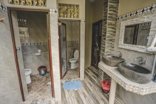 a bathroom with two sinks and a shower and a toilet at WW Backpackers in Ubud