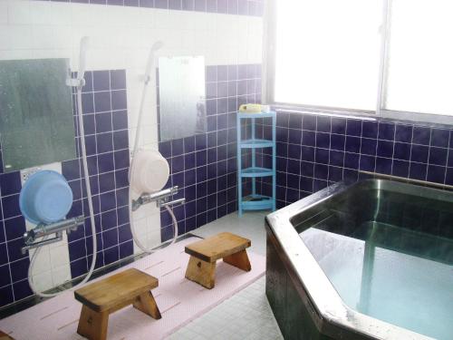 ein Badezimmer mit einer Badewanne, einem WC und einem Waschbecken in der Unterkunft Togakushi- Kogen Minshuku Rindo in Nagano