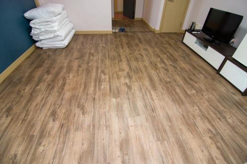 a room with a wooden floor and a tv and towels at Hyundai Elliot Hotel and Resort in Pyeongchang 