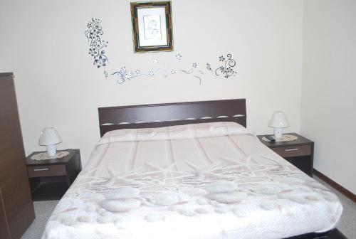 a bedroom with a large bed with two night stands at Stella Marina in Stintino