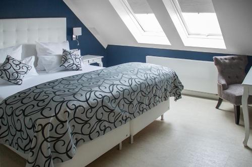 a bedroom with a black and white bed and a window at Haus Hotel & Pension Villa Laluna in Blankenburg