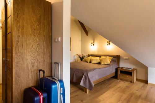 a bedroom with a bed and a room with a staircase at Hotel Beskidzki Raj Medical SPA in Stryszawa