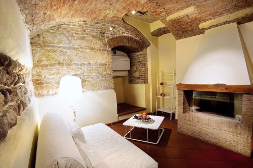 ヴェローナにあるLe Cadreghe Apartmentsの石造りの暖炉とソファ付きのリビングルーム