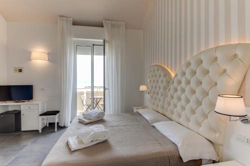ein Schlafzimmer mit einem großen Bett mit einem großen Kopfteil in der Unterkunft Hotel Miramare in Bellaria-Igea Marina