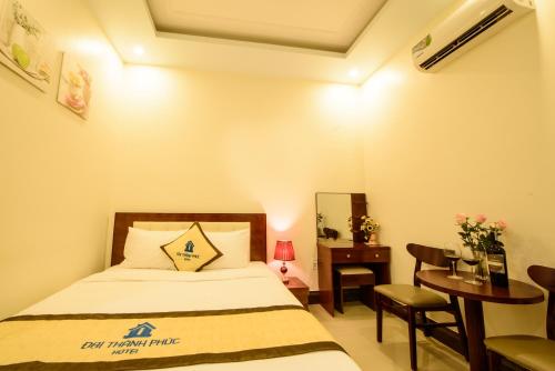 a bedroom with a bed and a table and a desk at ĐẠI THÀNH PHÚC in Hai Phong