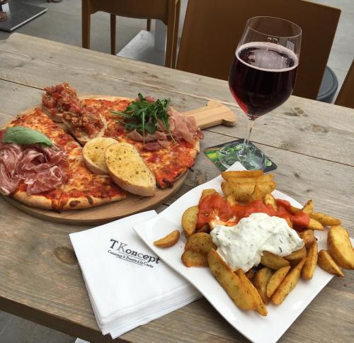 een tafel met een pizza en een glas wijn bij Melanie in Middelkerke