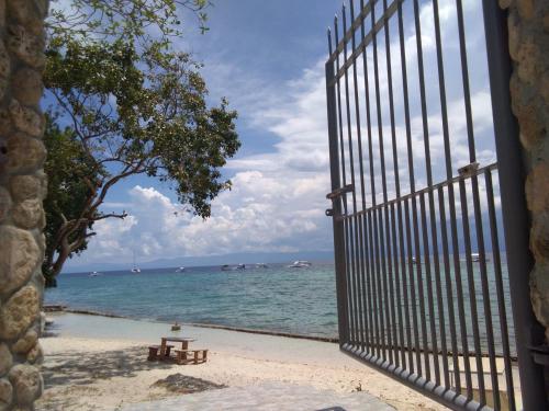 a gate to the beach with a bench in front of the ocean at Ancelle Cristo Re in Moalboal