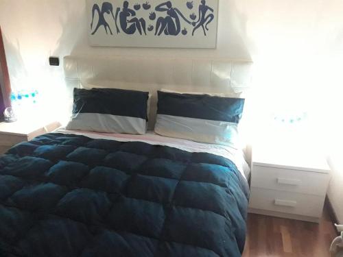 een bed met een blauw dekbed en 2 kussens bij La Giara in La Spezia