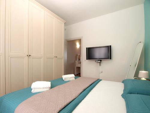 a bedroom with a bed and a flat screen tv at Apartment Mile 1872 in Fažana