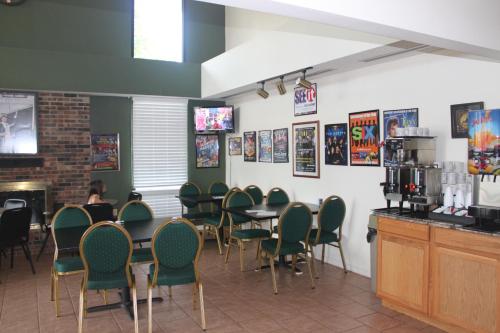 une salle à manger avec des chaises et des tables et une femme assise à un comptoir dans l'établissement Ozark Valley Inn, à Branson