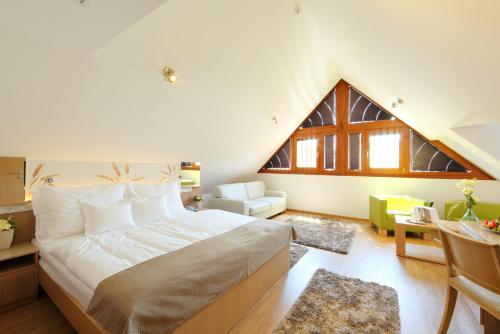 a bedroom with a large bed in a attic at Hotel Historia Malomkert in Veszprém