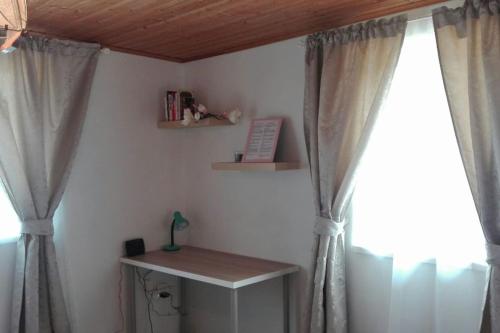 Zimmer mit Vorhängen, einem Tisch und einem Fenster in der Unterkunft U Pichlerů in Klipec