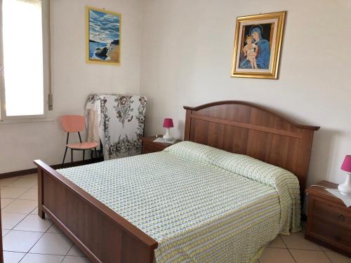 een slaapkamer met een bed en een stoel erin bij Castellan I in Grado