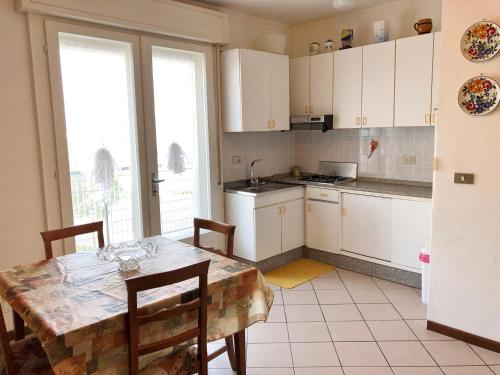 een keuken met witte kasten en een tafel met stoelen bij Castellan I in Grado