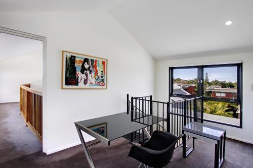 a white living room with a table and chairs at Byron Butter Factory Apartments in Byron Bay