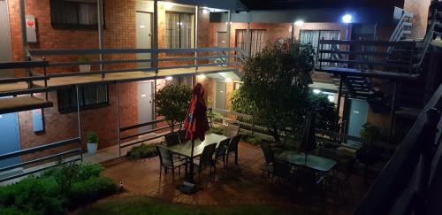 a balcony with a table and chairs in a building at Mahogany Motel Warrnambool in Warrnambool