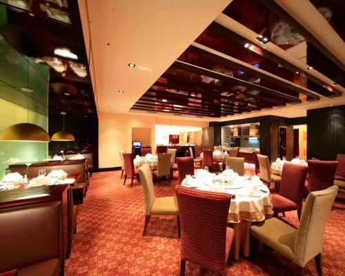 a dining room with tables and chairs in a restaurant at Furama Hotel Dalian in Dalian