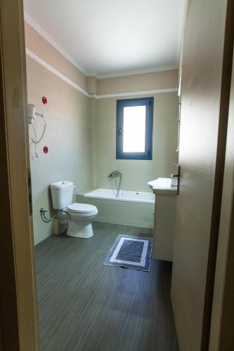 a bathroom with a toilet and a tub and a sink at Vista Del Mare Rooms in Nafplio