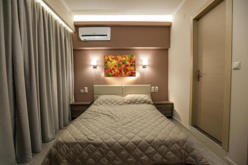 a bedroom with a bed and a painting on the wall at Vista Del Mare Rooms in Nafplio
