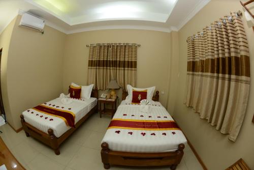 Postel nebo postele na pokoji v ubytování Bagan Comfort Hotel