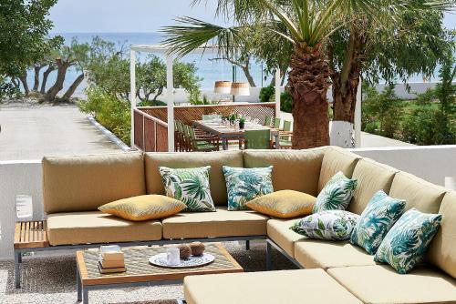 eine braune Couch mit Kissen auf einer Terrasse in der Unterkunft Beachfront Villa on Crete - Kirvas, member of Pelagaios Villas in Koutsounári