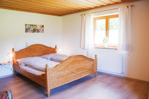 een slaapkamer met een houten bed en een raam bij Appartement Herzogbauer in Saalfelden am Steinernen Meer