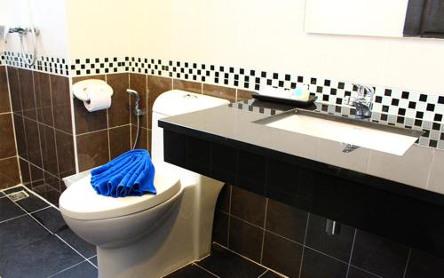 ein Badezimmer mit einem WC und einem Waschbecken mit einem blauen Handtuch in der Unterkunft 88 Hotel in Patong Beach