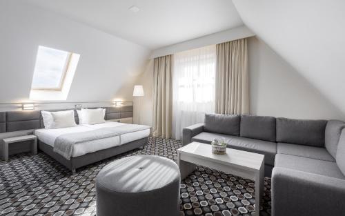 a hotel room with a bed and a couch at Kocierz Resort in Targanice