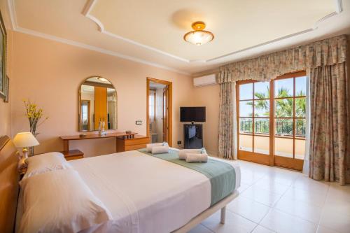 Un dormitorio con una cama grande y una ventana en Villa Palmera en Ibiza