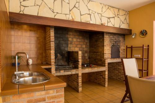 a kitchen with a sink and a brick oven at Villa Palmera in Ibiza Town