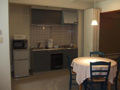 a kitchen with a table and a kitchen with a table and chairs at Sundance Resort Kawaguchiko in Fujikawaguchiko