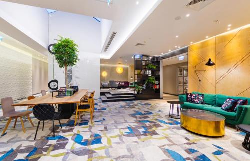 a living room with a green couch and a table at Mercure Warszawa Grand in Warsaw