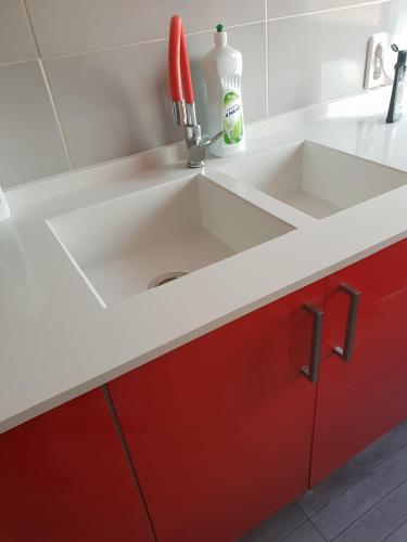 a kitchen with a sink and red cabinets at Avenue Rooms in Valencia