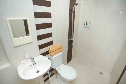 a bathroom with a white toilet and a sink at Hotel O Lapan Lapan in Banjarmasin