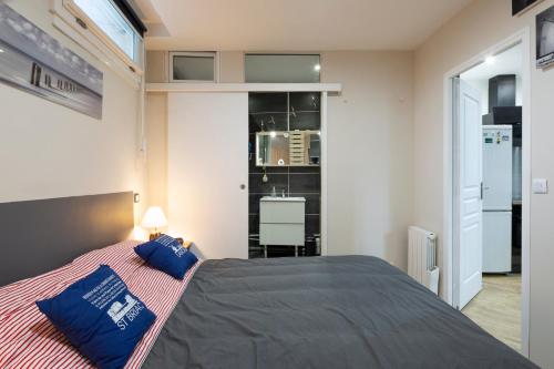 a bedroom with a bed with blue pillows on it at Les Bois Flottés in Saint Malo