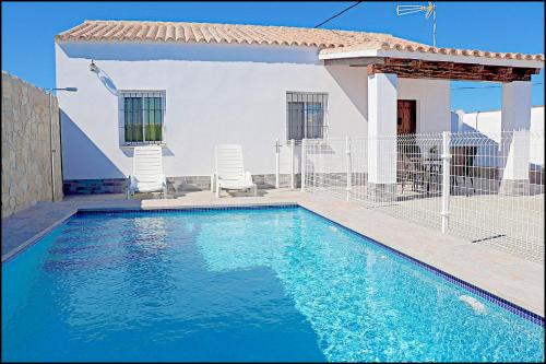 - une piscine en face d'une maison dans l'établissement Chalet Ermita, à Conil de la Frontera