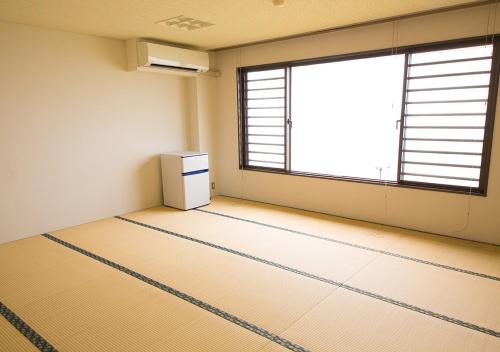 Habitación vacía con nevera y ventana en Sea Aiga Kaigetsu, en Sumoto