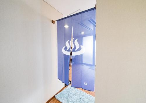 Una puerta azul con un cartel en una habitación en Sea Aiga Kaigetsu, en Sumoto