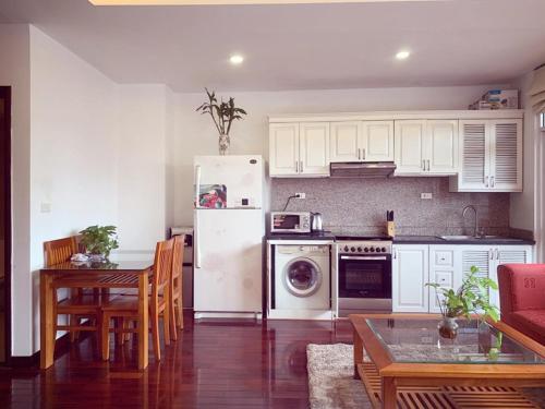 a kitchen with a white refrigerator and a table at Beautiful APT in Ha Noi KT in Hanoi