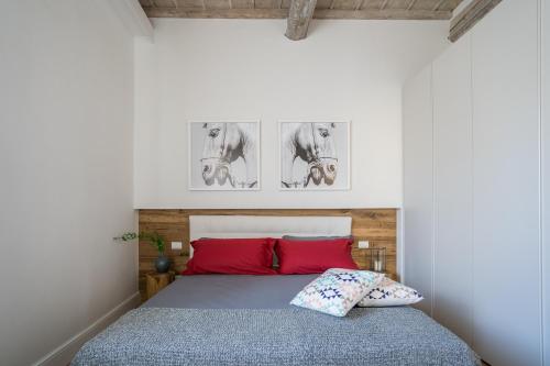 a bedroom with a bed with two red pillows at Olive Loft in Florence