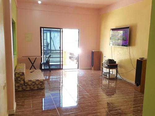 ein Wohnzimmer mit Sofa und Fernseher in der Unterkunft Aaliyahs Place in Puerto Princesa