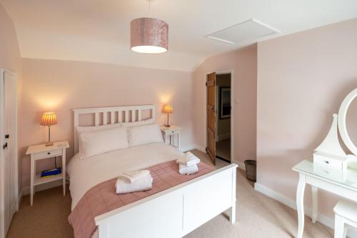 1 dormitorio con 1 cama blanca y 2 mesitas de noche en Little Tern Cottage, en Aldeburgh
