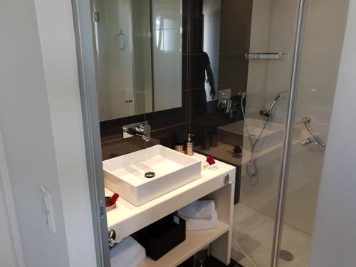 a bathroom with a white sink and a shower at ANGELIKA HOUSE 1 in Marathias
