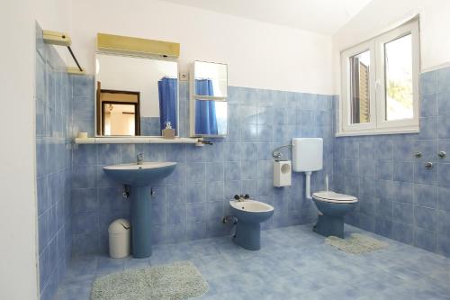 ein Badezimmer mit Waschbecken, Toilette und Spiegel in der Unterkunft Villa Palma in Petrcane