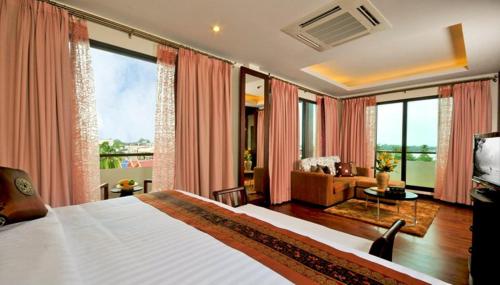 - une chambre avec un grand lit et un salon dans l'établissement Salana Boutique Hotel, à Vientiane