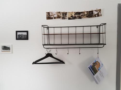 a black shelf on a wall with pictures at Brukshotellet Skinnsberg in Skinnskatteberg