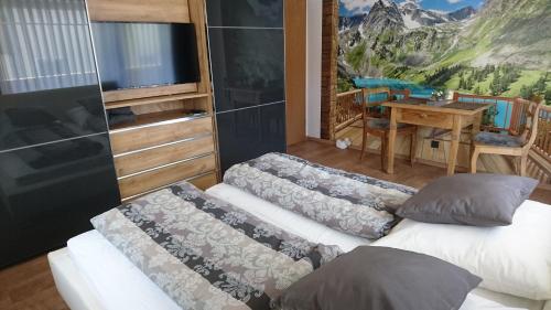 two beds in a room with a tv and a desk at Ferien Wohnung "Kaiser" mit Balkon und Garten in Offenhausen